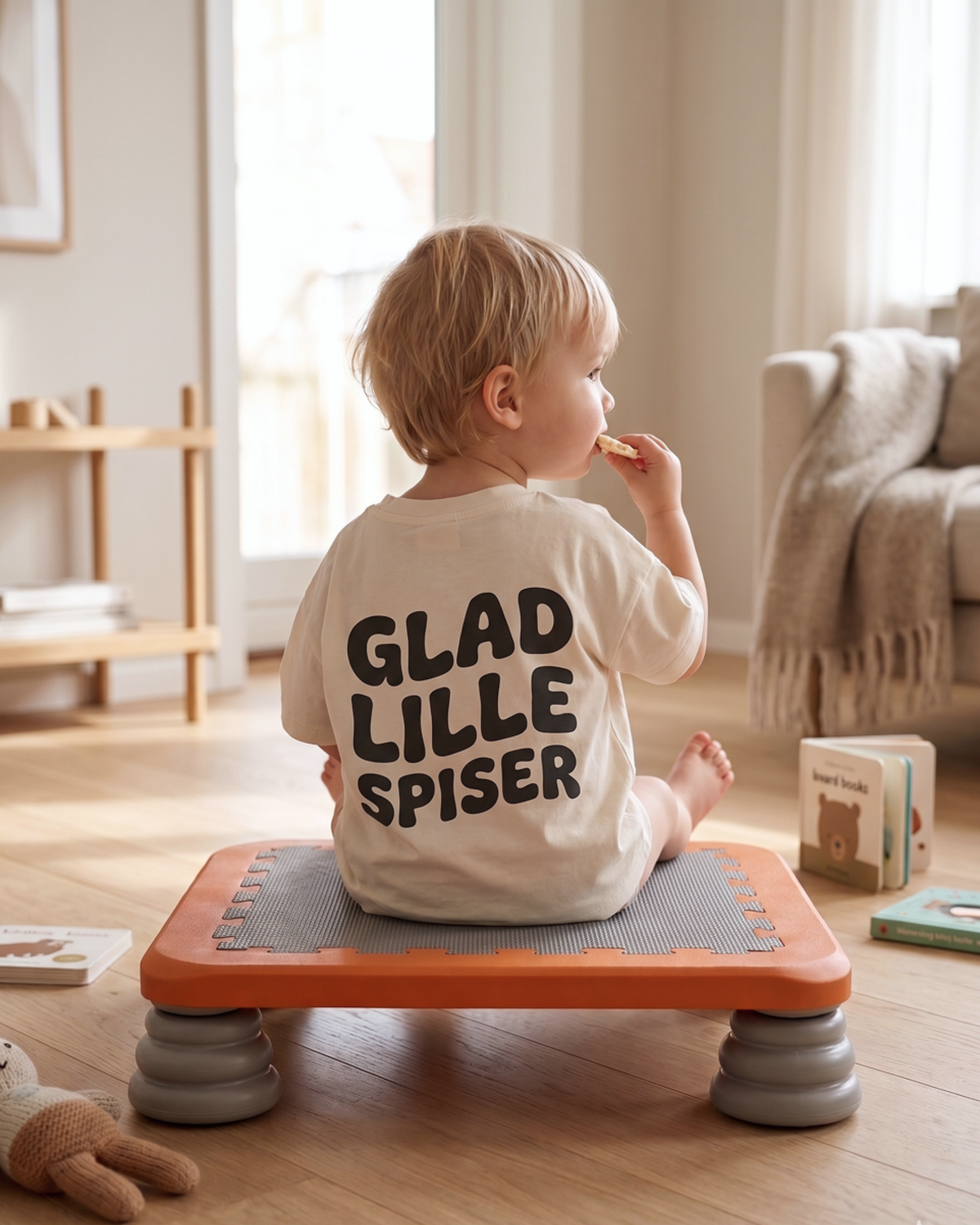 Barn sidder og hviler på TUMLE TRAMPOLIN™ i stuen