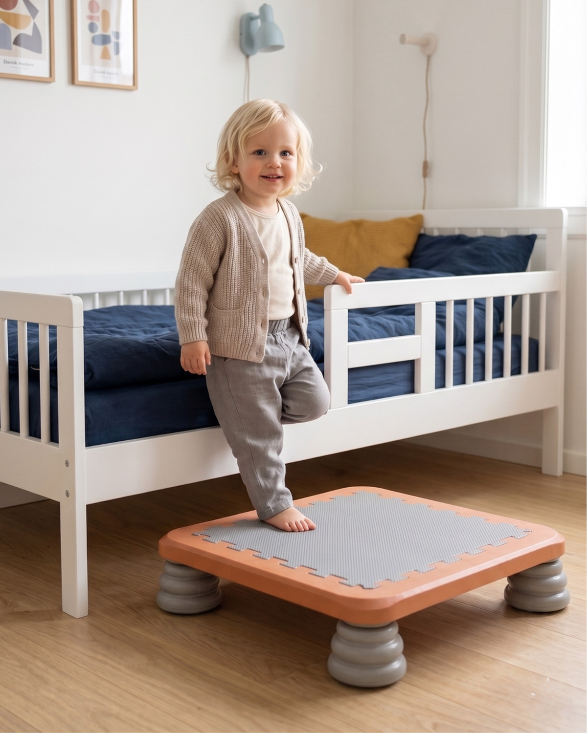 Barn står på TUMLE TRAMPOLIN™ ved sengen på børneværelset