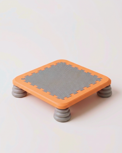 TUMLE TRAMPOLIN™ i orange med grå hoppeflade, set fra siden